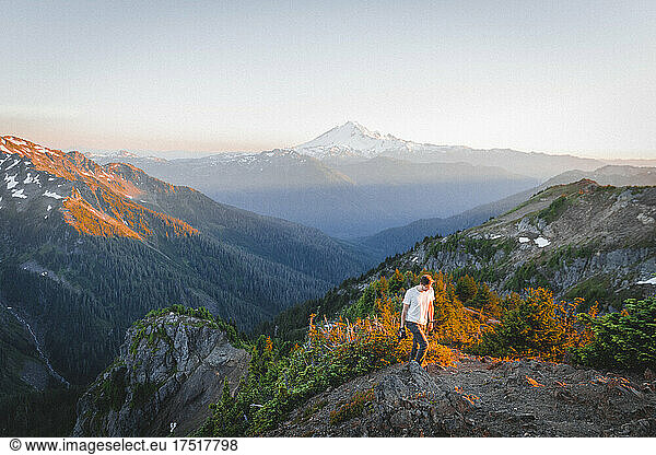 A man with a camera is walking in North Cascades near mt. Baker