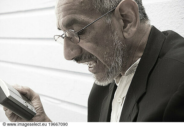 A man with a electronic device in his hand.