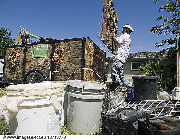 A man works with his crew to clean up a bank-owned  foreclosed house.