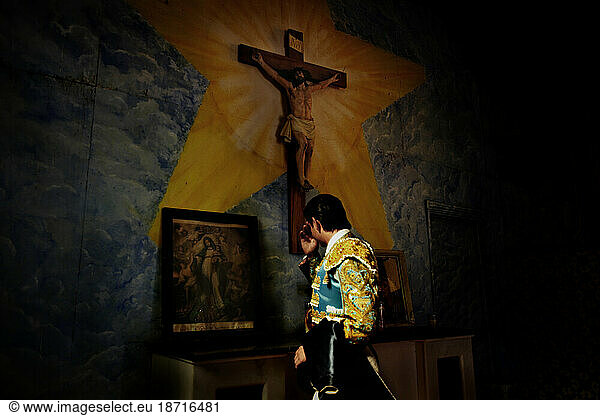 A matador prays for his health in the church at Plaza Monumental  Tijuana  Mexico.