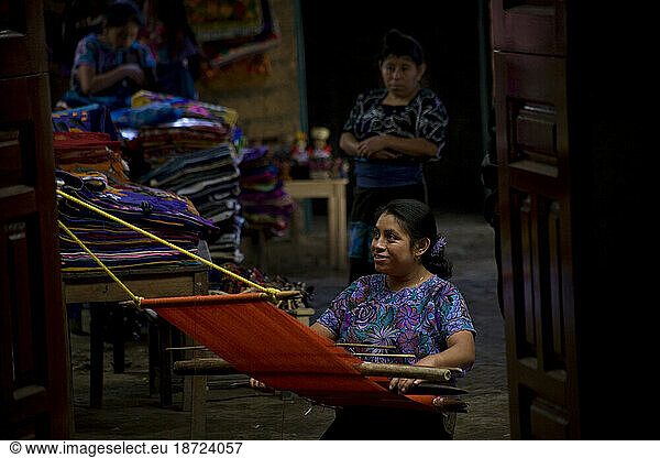 A Mayan Tzotzil woman weaves for tourists in a souvenir shop in Zinacantan  Chiapas  Mexico