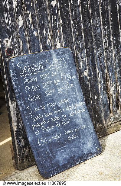 A menu board advertising seasonal suppers with details.
