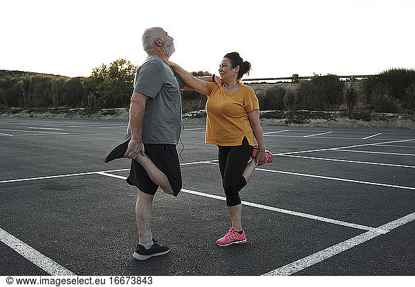 A middle-aged couple are doing stretching exercises together