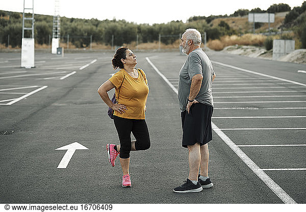 A middle-aged man and woman get ready to exercise