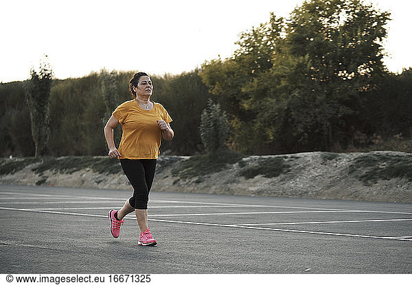 A middle-aged woman is jogging