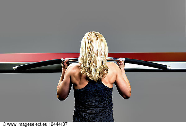 A middle-aged woman working out at a fitness facility doing chin-ups  Spruce Grove  Alberta  Canada