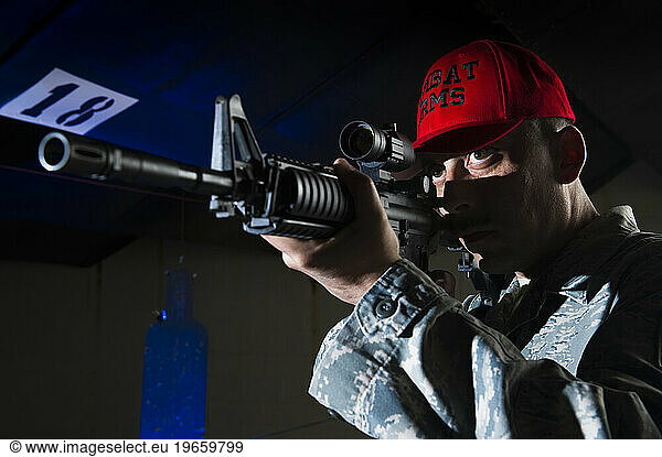 A military police officer stands at the shooting range with his rifle.