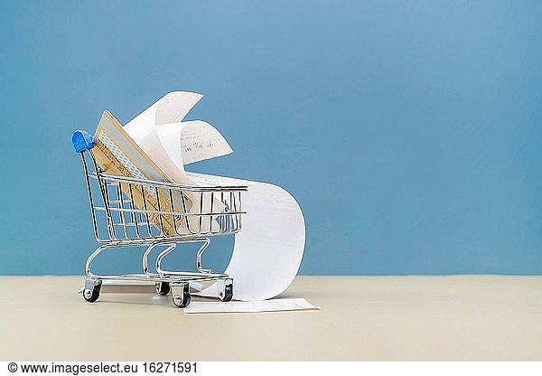 A mini shopping cart full of bank CARDS and bills