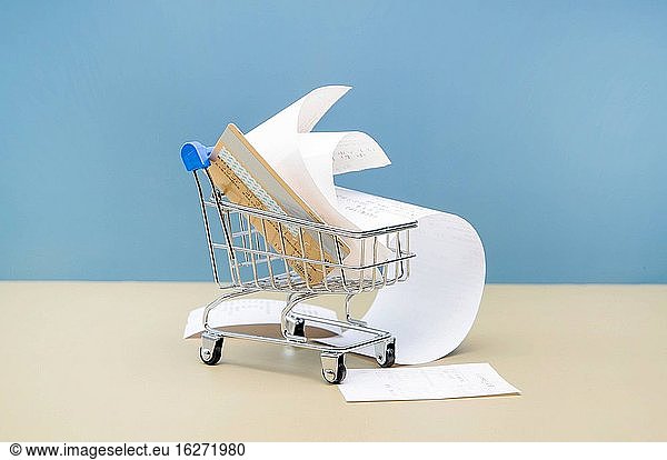 A mini shopping cart full of bank CARDS and bills