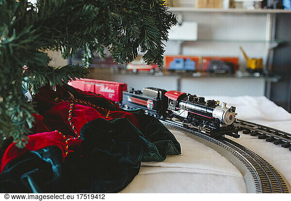A model train and track ride around a Christmas tree in a shop