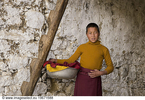 A monk holding a wash bin in Lingshi  Bhutan.
