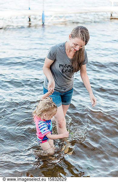 A mother and her daughter cooling off at the lake.
