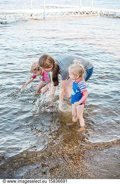 A mother and her girls cooling off at the lake.