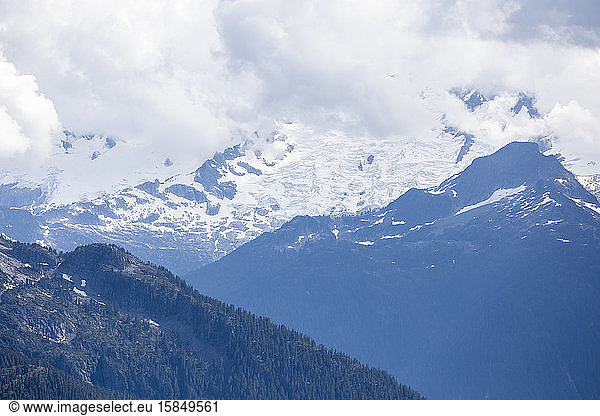 A mountain peak with a massive glacier is shrouded in clouds.