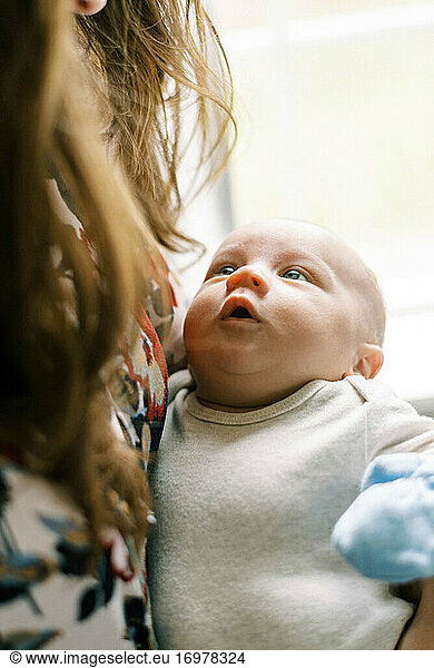 A newborn baby looking up at his mother