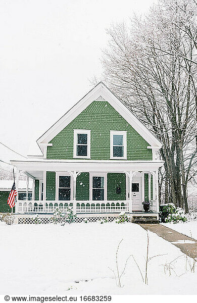 A nineteenth century New England home buried in the snow in spring.