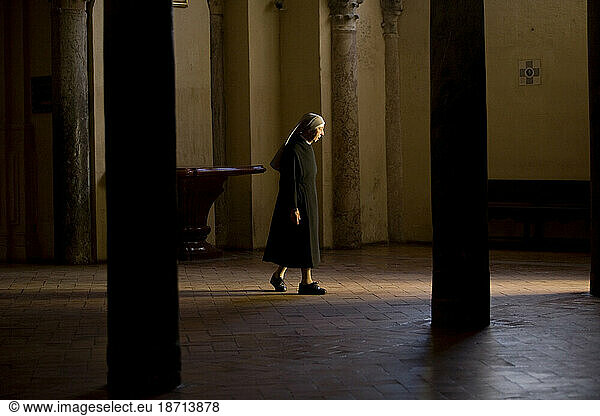 A nun walks in the Mosque and Cathedral of Cordoba  Andalusia  Spain.