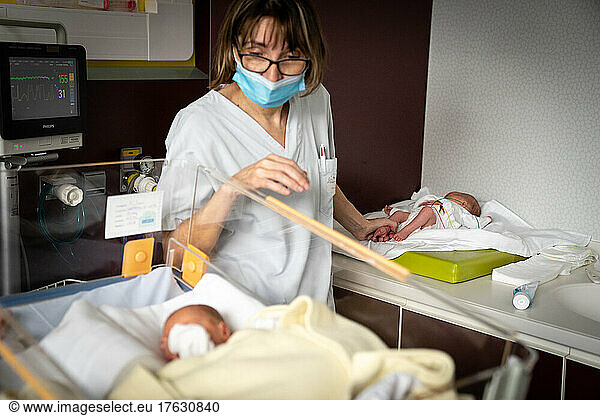 A nurse cares for twins born prematurely in a hospital.