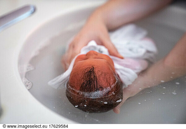 A nurse gives a baby her first bath. This is a wrapped bath.