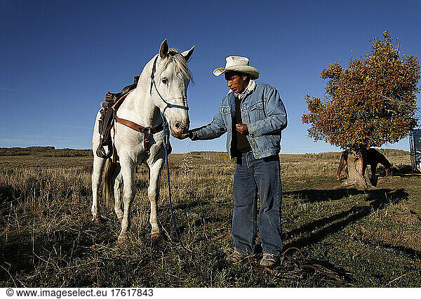 A once wild horse now works the Wyoming range with a sheepherder; Savery  Wyoming  United States of America