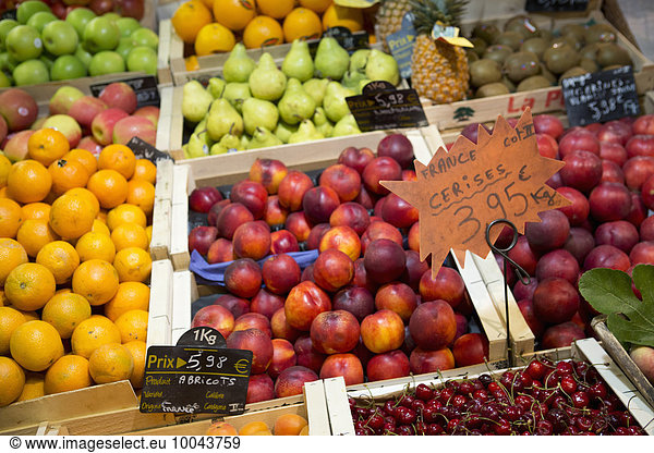 A packed fruit market stall  with fresh fruit on display.