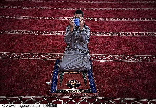 A Palestinian Muslims man pray wearing a face mask as a precaution  during Friday prayers in Southern Gaza  May 22  2020. Authorities have decided to partially reopen mosques for prayers on the last Friday in the blessed month of Ramadan nearly after two months after closure due to the Coronavirus (COVID-19).