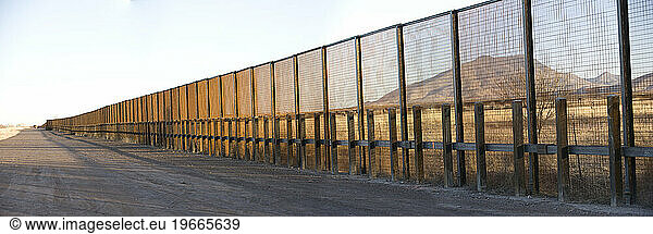 A pedestrian-style fence runs along the Mexican border in Arizona.