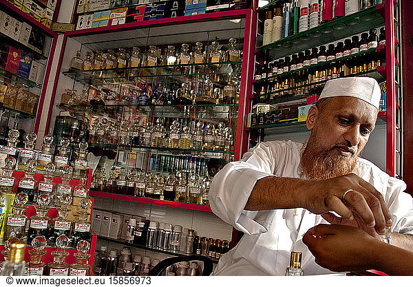 A perfume and essence muslim seller attends client