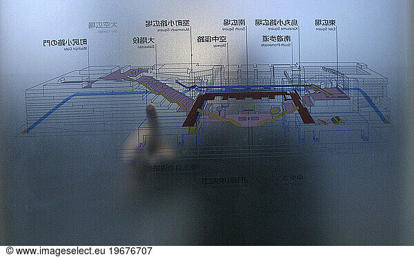 A person points to a location on a transparent map in the Kyoto train station  Kyoto  Japan.