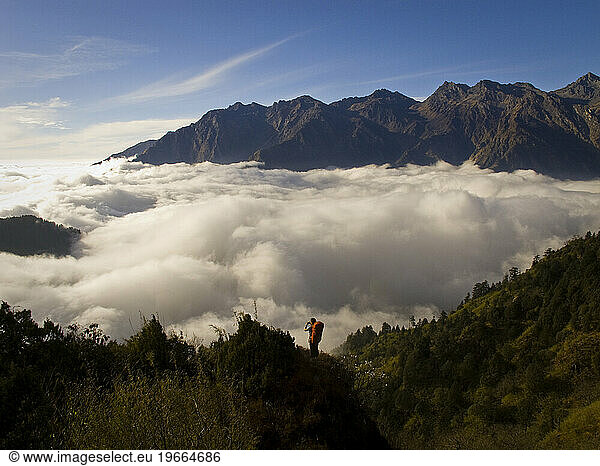A person taking in the view above the clouds while trekking the Helambu Circuit  Nepal