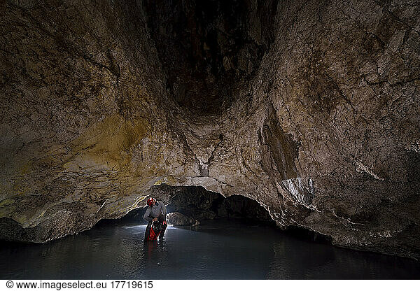A photo assistant ducks under a low arch inside Cueva de Villa Luz in Tabasco  Mexico