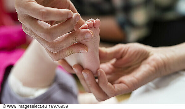 a physiotherapist manually treats an infant's foot