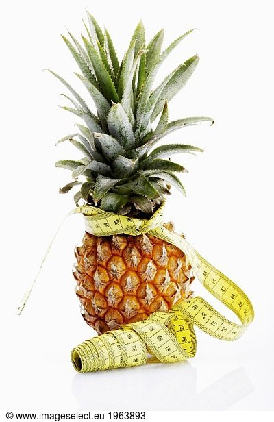 A pineapple with a tape measure