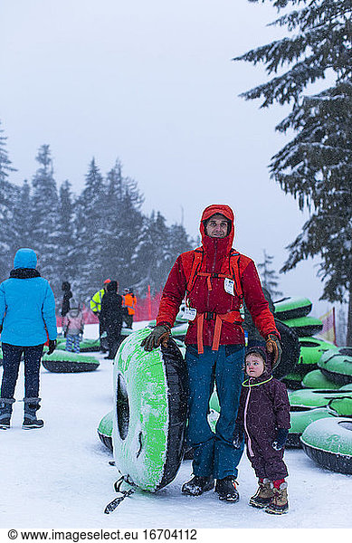 A portrait of a father and his daughter at the tubing hill in Oregon.