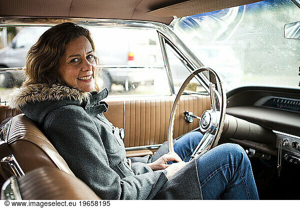 A portrait of a writer on a chilly fall day in the northwest while she sits in a classic old car.