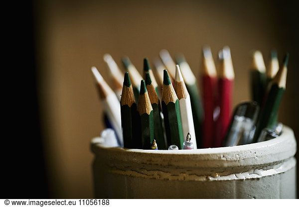 A pot of sharpened coloured lead pencils.