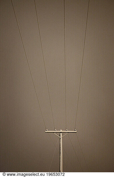 A powerline covered in snow at night.