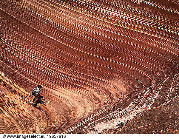 A ranger walks within the striations of the Wave