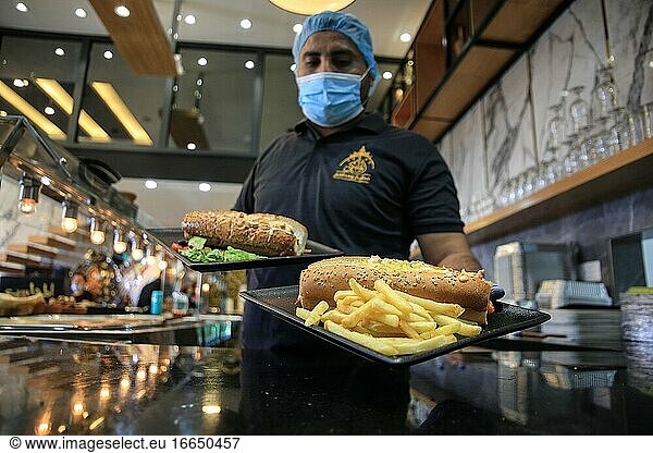 A restaurants employee wearing protective mask  work at a restaurants  in Gaza City  October 13  2020. Palestinian authorities allowed cafes and restaurants to reopen under strict regulations after one month closure as the COVID-19 outbreak in the Gaza Strip.