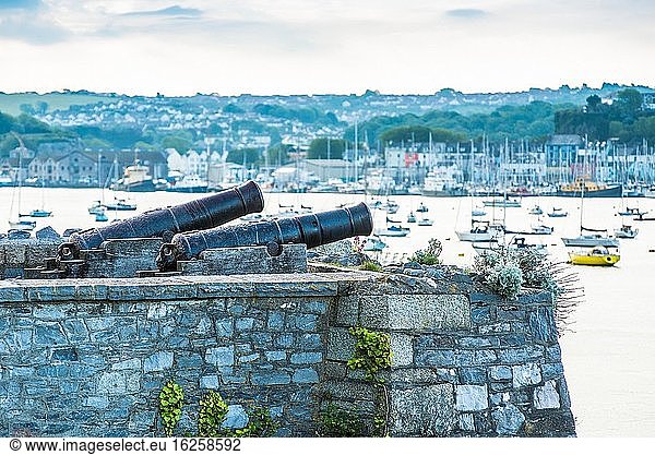 A restored 19th century Blomefield design cast iron cannons points across the water on Plymouth seafront in south Devon  UK.