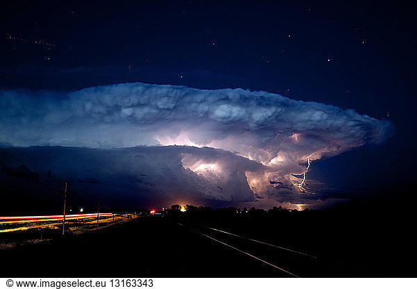 A rotating supercell storm lights up with lightning as stars shine overhead  Near Sidney  Nebraska  USA