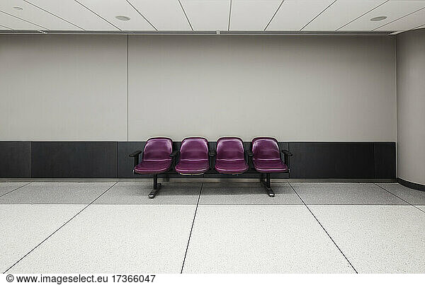 A row of four fixed seats in an empty airport