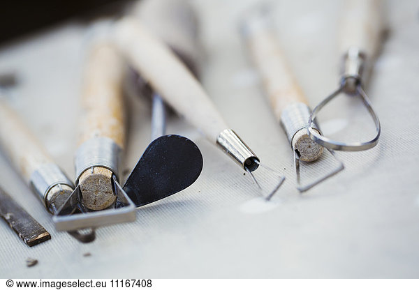 A row of hand tools for potters on a workbench. Wire shaping tools.