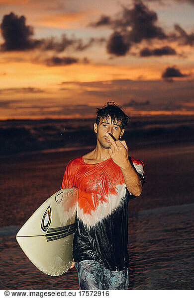 a rude surfer making hand signs after a surfing session