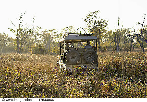A safari vehicle on a sunrise game drive