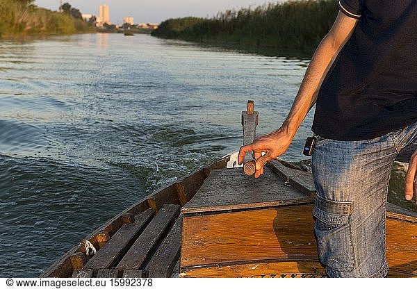 A sailor guides the helm of the boat in the Albufera of Valencia  Spain