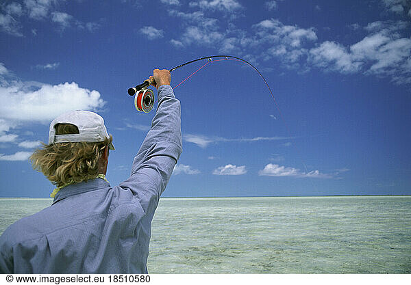 A saltwater fly-fisherman fights a fish in the Bahamas.