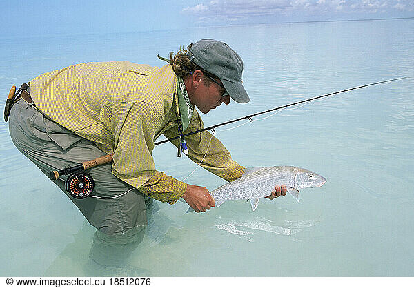A saltwater fly-fisherman holds a trophy bonefish.