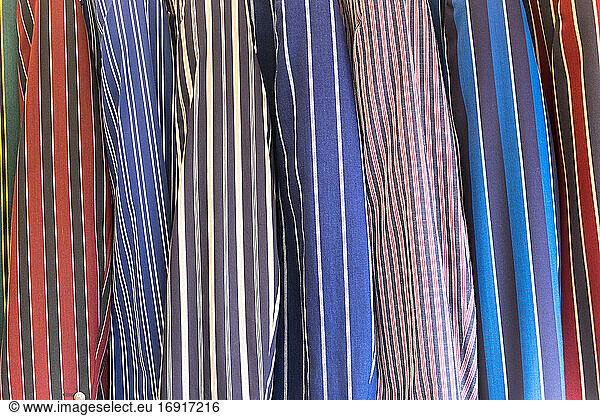 A selection of striped blazers on a rack  traditional leisure wear.