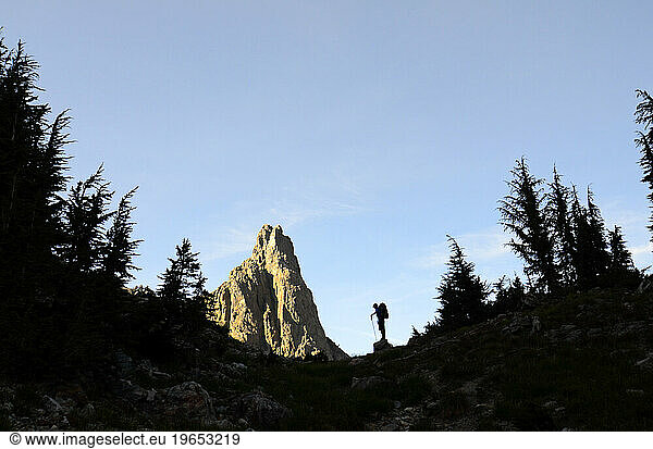 A silhouette of a backpacker next to one of the Minarets on the Sierra High Route  CA.